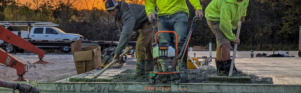 MBW ScreeDemon vibratory screed striking off a fresh concrete slab at sunset
